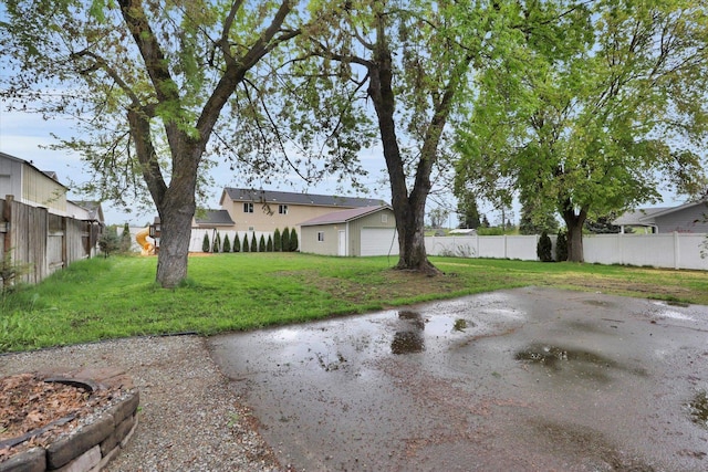 view of yard featuring fence and a detached garage