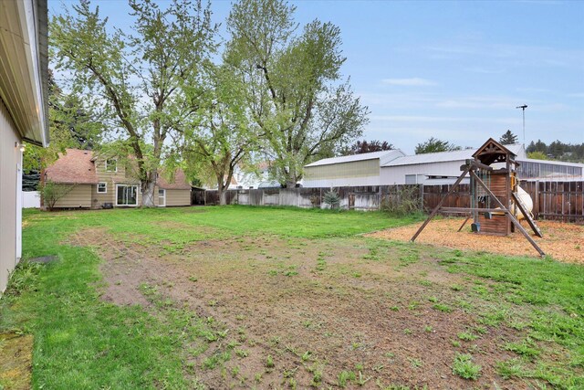 view of yard with a fenced backyard and a playground