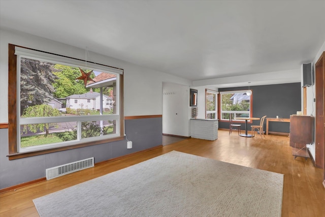 living area featuring visible vents and wood finished floors