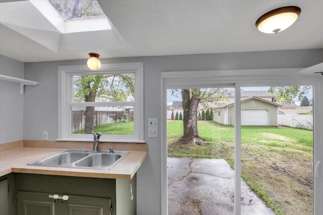 kitchen with a sink, a skylight, and light countertops