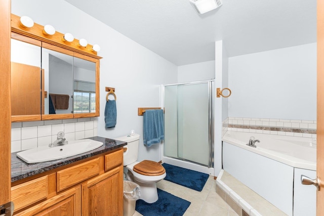 bathroom featuring vanity, toilet, tile patterned floors, backsplash, and a stall shower