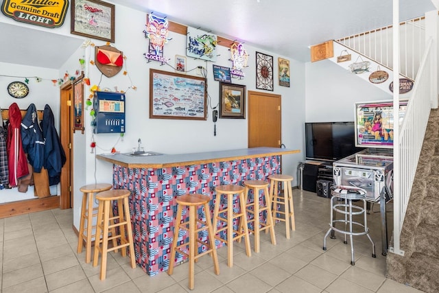 bar featuring indoor wet bar, tile patterned floors, and stairway