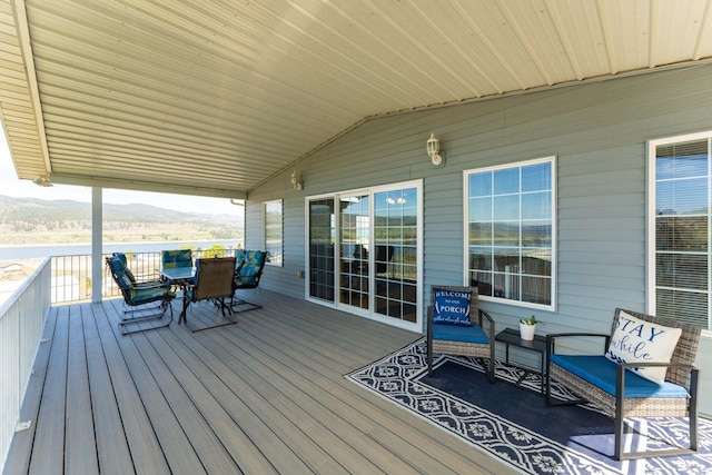 wooden deck with outdoor dining area and a mountain view