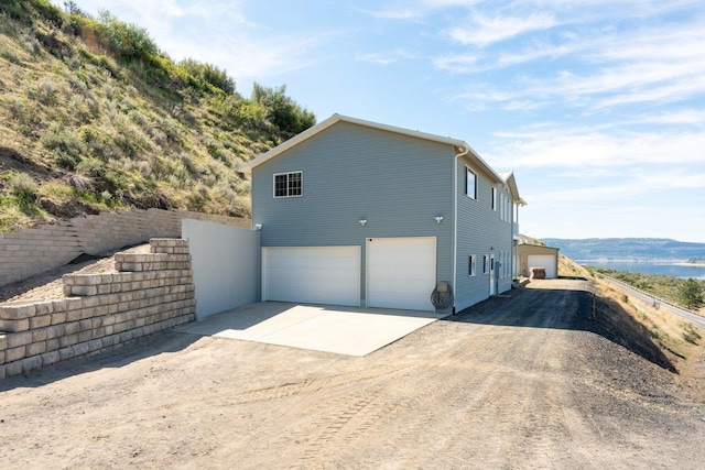 view of side of home featuring an attached garage and driveway