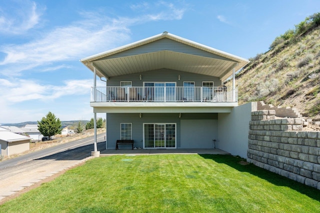 back of property featuring a yard and a balcony