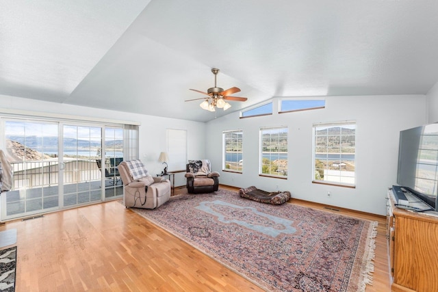 sitting room with a healthy amount of sunlight, ceiling fan, wood finished floors, and lofted ceiling