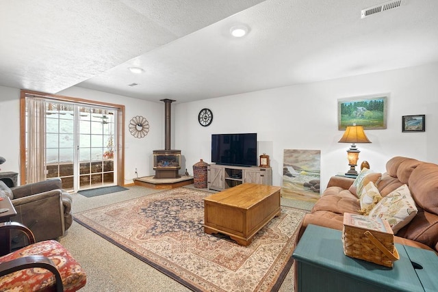 815 E Shelter Ln, Deer Park, WA 99006 - living room with a wood stove, carpet flooring, a textured ceiling, and recessed lighting