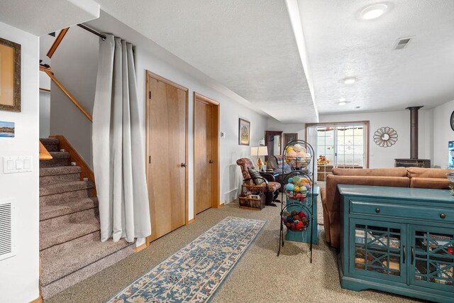 815 E Shelter Ln, Deer Park, WA 99006 - carpeted living room with a textured ceiling, a wood stove, and stairway