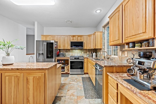 815 E Shelter Ln, Deer Park, WA 99006 - kitchen featuring stainless steel appliances, a sink, light brown cabinets, tasteful backsplash, and light stone finish floors