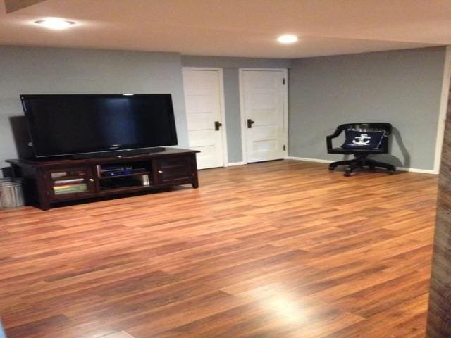 living room featuring baseboards, recessed lighting, and wood finished floors