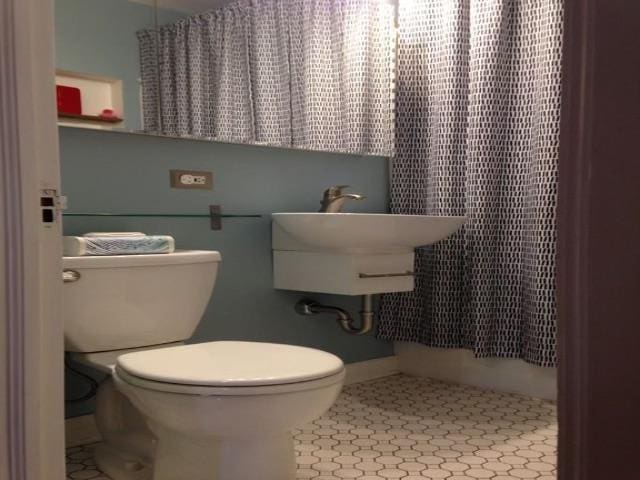 full bath featuring a shower with curtain, tile patterned flooring, and toilet