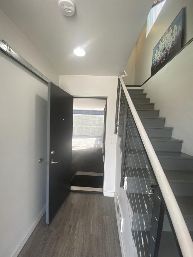 stairway with baseboards and wood finished floors