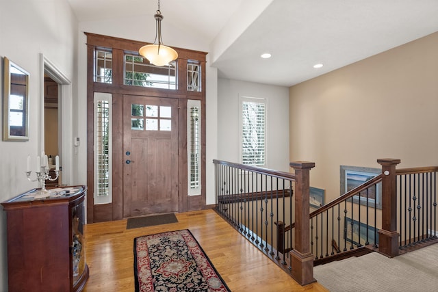 foyer with recessed lighting, wood finished floors, and lofted ceiling