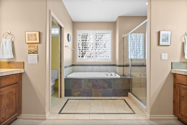 full bathroom featuring vanity, baseboards, a shower stall, and a garden tub