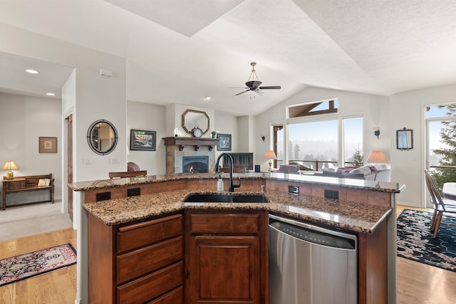 kitchen with stainless steel dishwasher, a sink, ceiling fan, and open floor plan