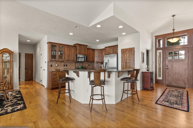 kitchen featuring a sink, light wood finished floors, a breakfast bar area, and stainless steel appliances