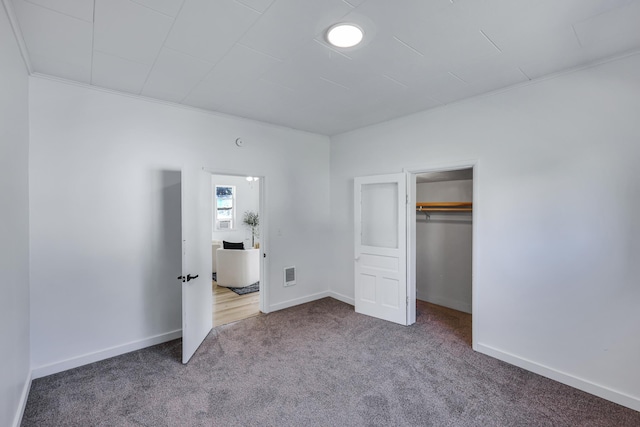 unfurnished bedroom with carpet flooring, baseboards, and visible vents