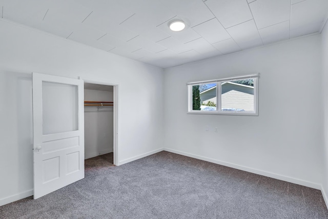 unfurnished bedroom featuring carpet flooring, baseboards, and a closet