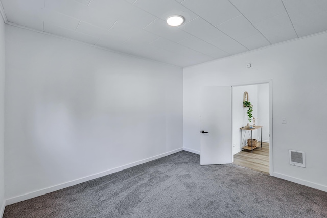 carpeted empty room featuring visible vents and baseboards