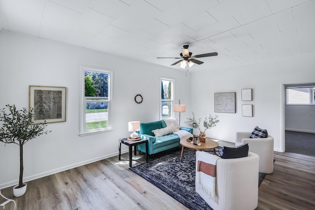 living room with plenty of natural light, a ceiling fan, baseboards, and wood finished floors