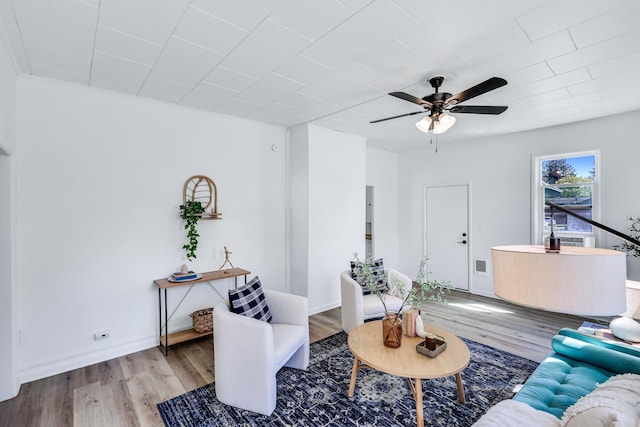 living room featuring baseboards, a ceiling fan, wood finished floors, and visible vents