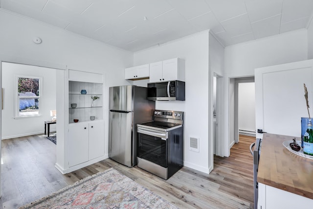 kitchen featuring crown molding, visible vents, light wood-style floors, white cabinets, and appliances with stainless steel finishes