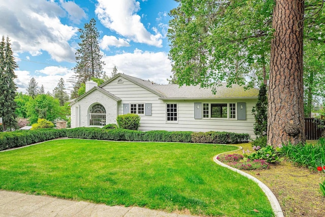 single story home featuring a chimney and a front yard