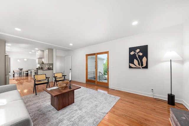 living room with baseboards, recessed lighting, light wood-style flooring, and visible vents