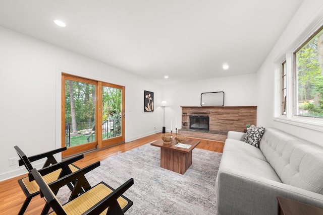 living area with plenty of natural light, recessed lighting, and a stone fireplace