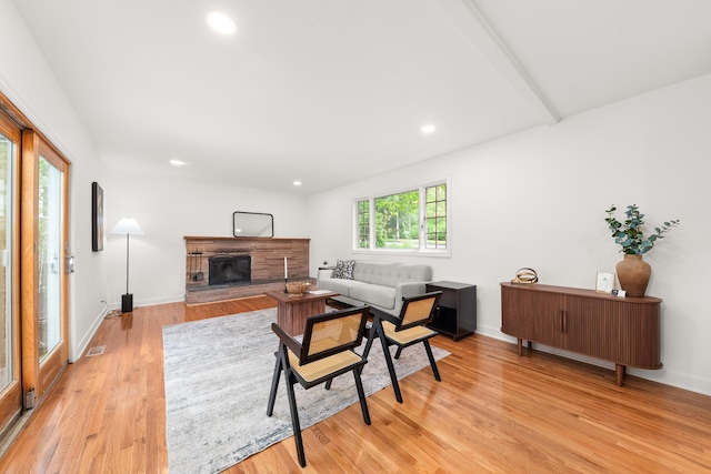 living area featuring recessed lighting, baseboards, a fireplace, and light wood finished floors