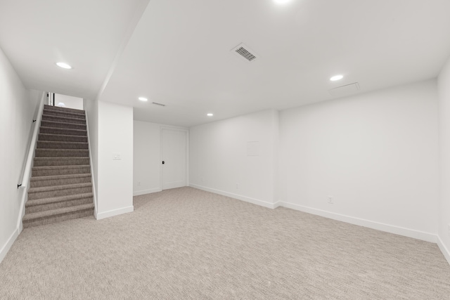 finished below grade area with recessed lighting, baseboards, visible vents, and stairway