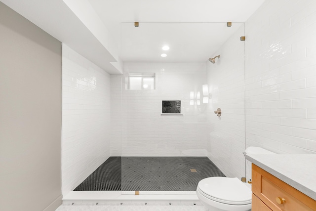 full bath featuring toilet, tiled shower, and vanity