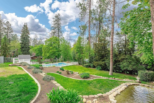 view of yard featuring a fenced in pool, an outbuilding, and a fenced backyard