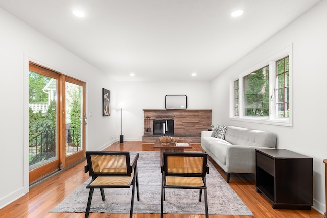 living room with recessed lighting, light wood-style floors, baseboards, and a fireplace