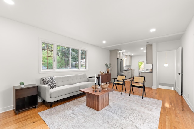 living area with recessed lighting, baseboards, and light wood finished floors