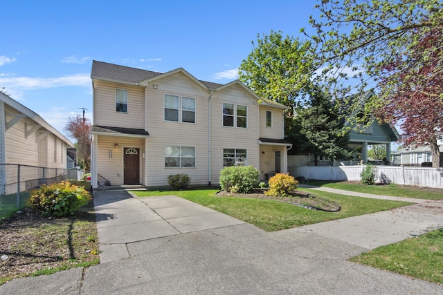 view of front of home with a front lawn and fence