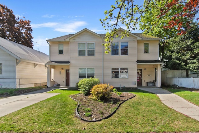traditional home featuring fence and a front lawn