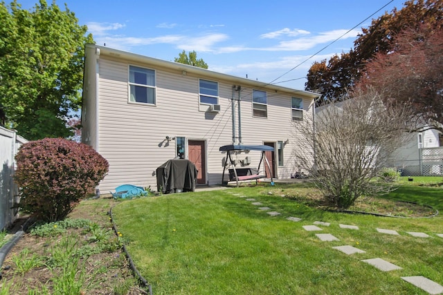back of property with a yard and fence