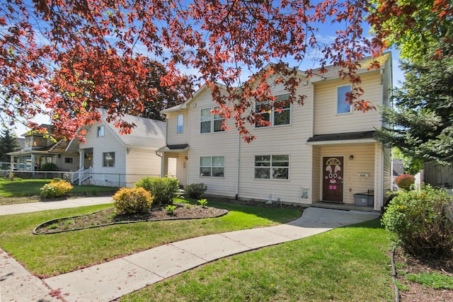 view of front of home featuring fence and a front lawn