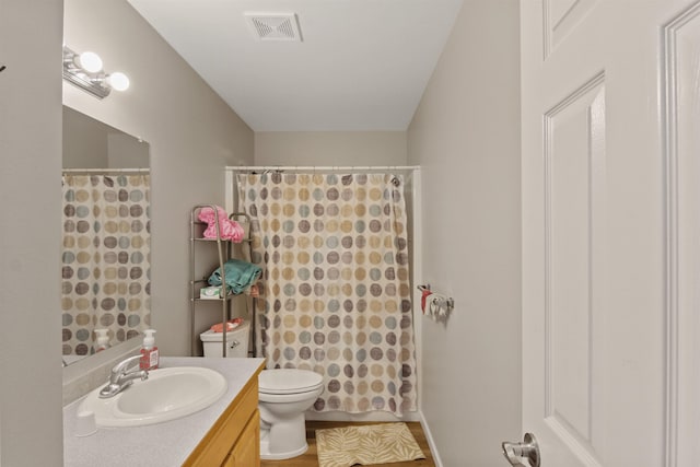 full bathroom featuring vanity, a shower with shower curtain, toilet, and visible vents