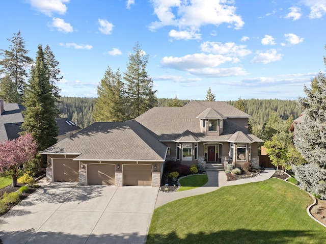 craftsman house featuring an attached garage, driveway, a front lawn, and stone siding