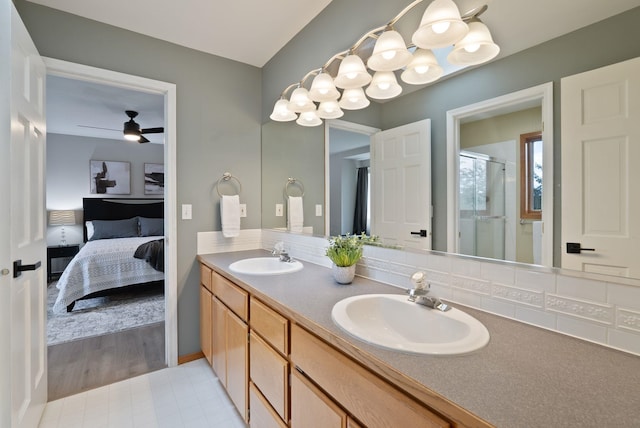 ensuite bathroom with double vanity, ensuite bath, a sink, and a stall shower