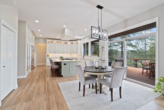 dining room with an inviting chandelier, recessed lighting, baseboards, and light wood-type flooring