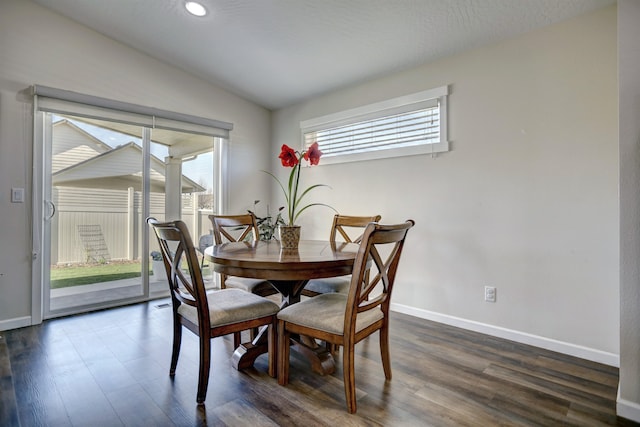 dining area featuring baseboards, lofted ceiling, and dark wood-type flooring