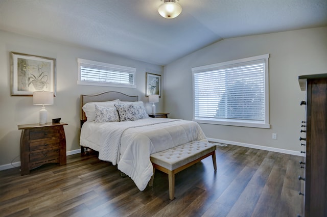 bedroom featuring dark wood-style flooring, baseboards, vaulted ceiling, and multiple windows
