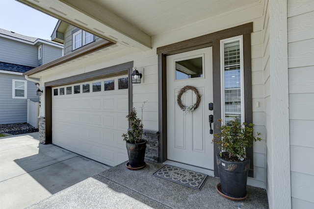 property entrance featuring concrete driveway and a garage