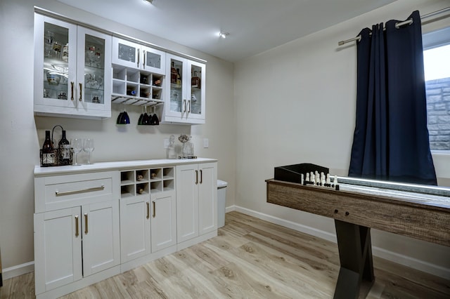 bar featuring baseboards and light wood finished floors