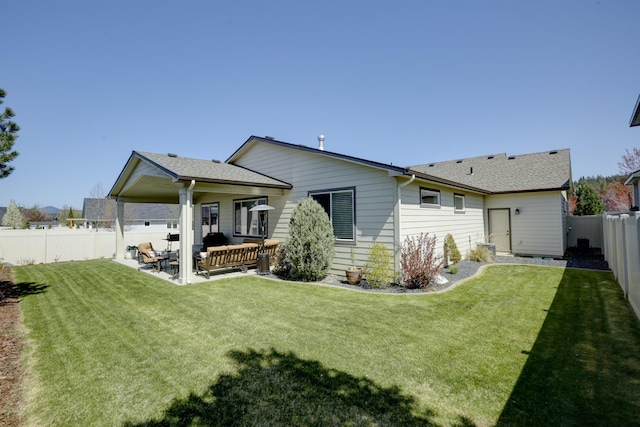 rear view of property featuring a yard, an outdoor living space, a fenced backyard, and a patio area