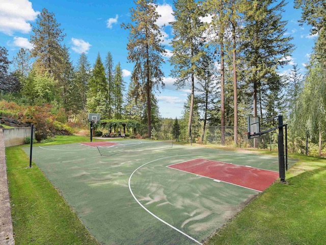view of sport court with fence, community basketball court, and a yard