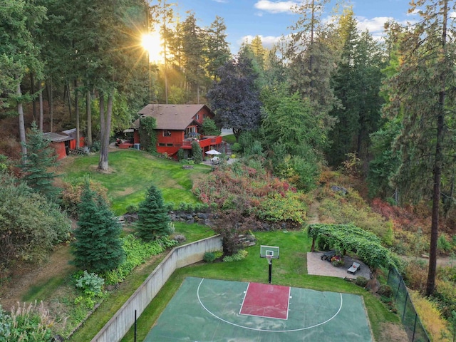 view of basketball court featuring basketball court, a yard, and fence